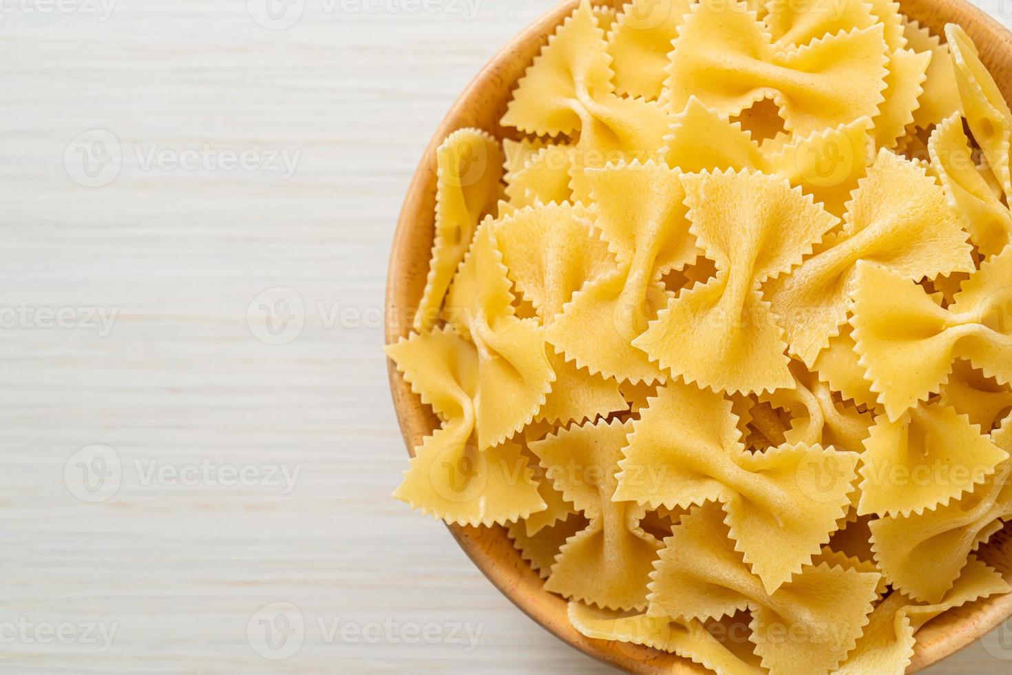 pasta secca di farfalle crude in una ciotola foto