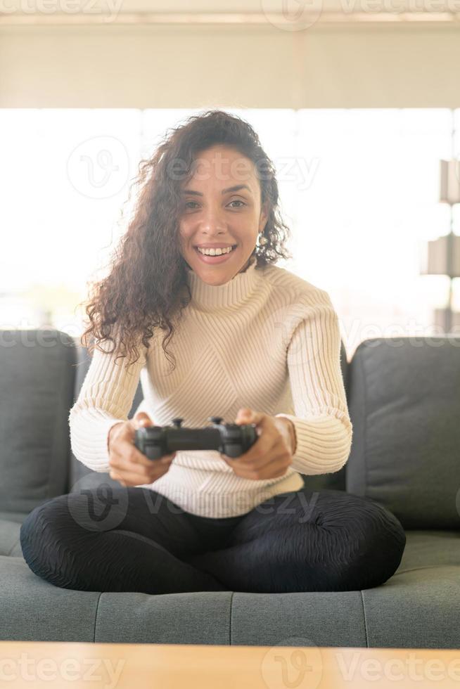 donna latina che gioca ai videogiochi con le mani che tengono il joystick foto