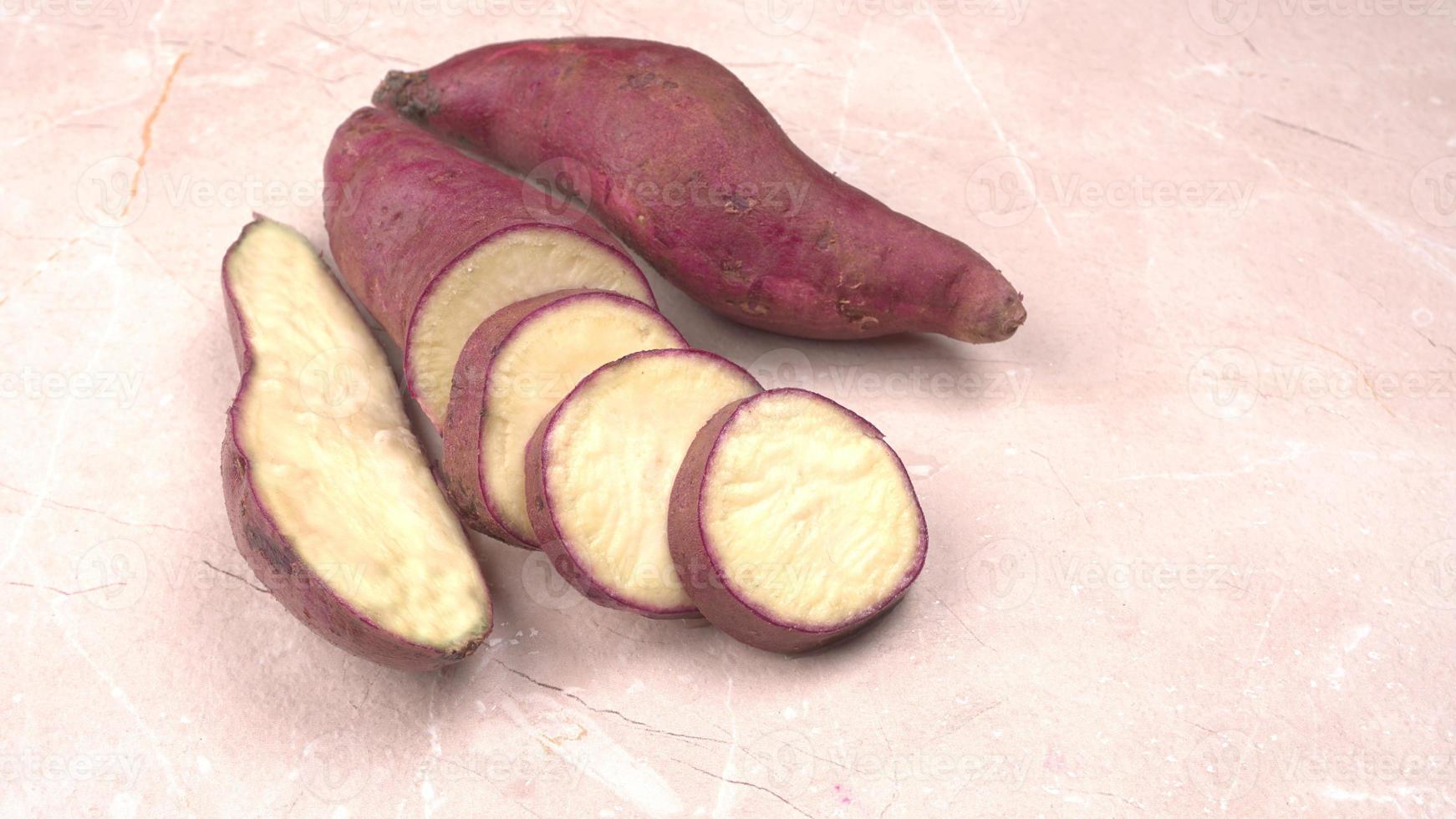 fette di patate dolci su fondo di legno, primo piano. patate dolci crude o batatas. foto