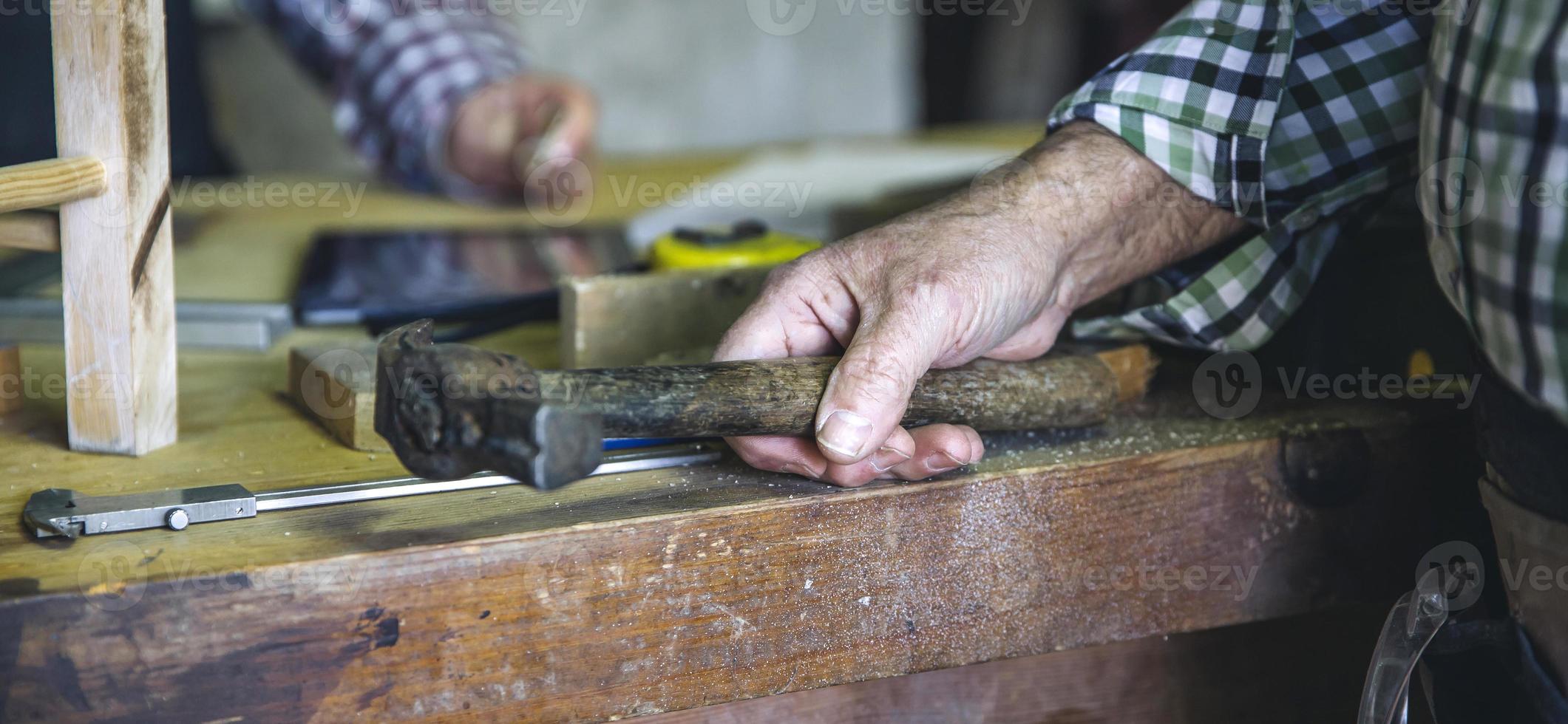 la mano del carpentiere che tiene un martello foto