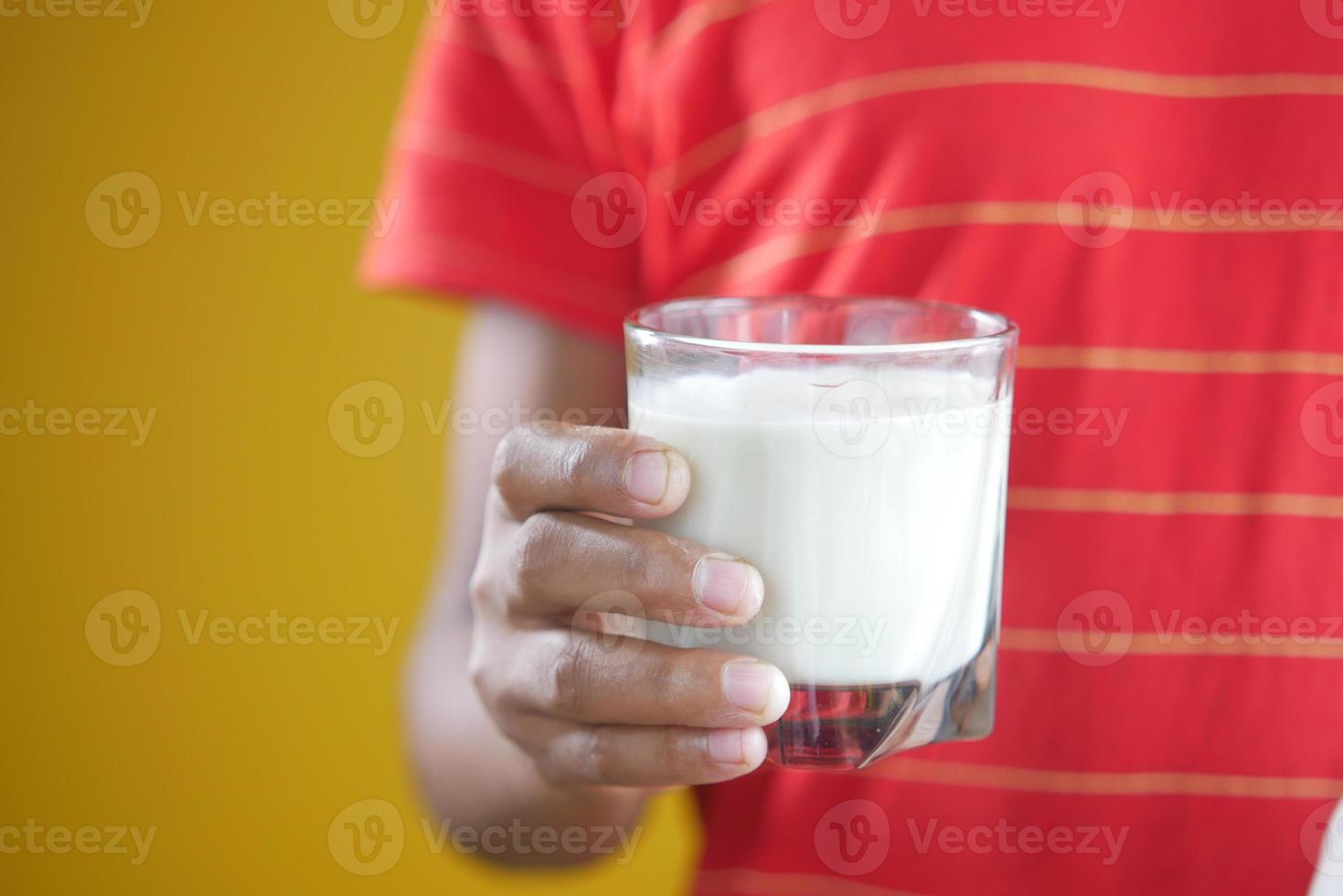 bambino ragazzo mano tenere un bicchiere di latte foto