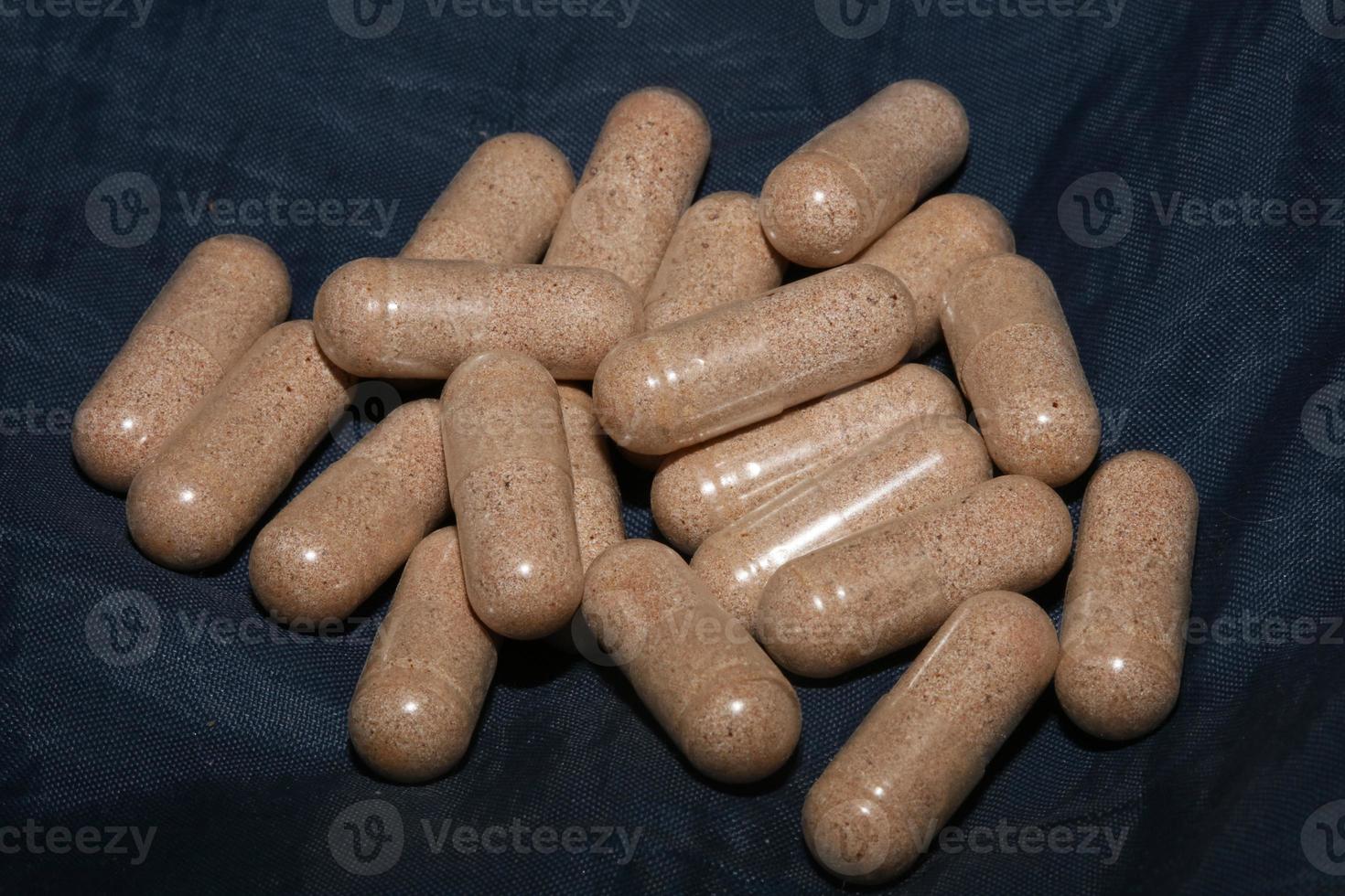 capsule trasparenti riempite con polvere di vitamine marrone close up sfondo stampe di grandi dimensioni di alta qualità foto
