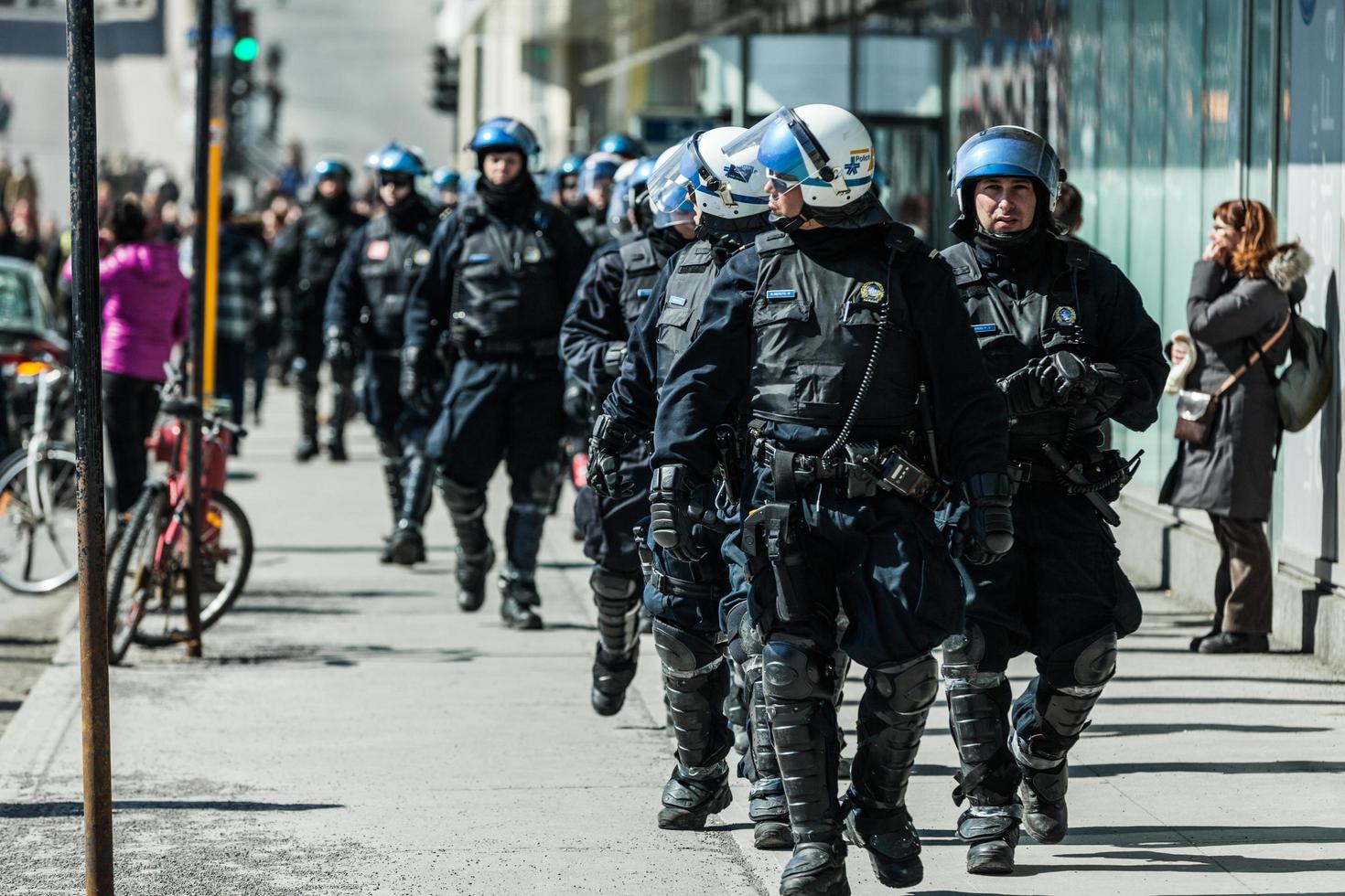 montreal, canada, 2 aprile 2015 - poliziotti seguono i manifestanti in caso qualcosa vada storto foto