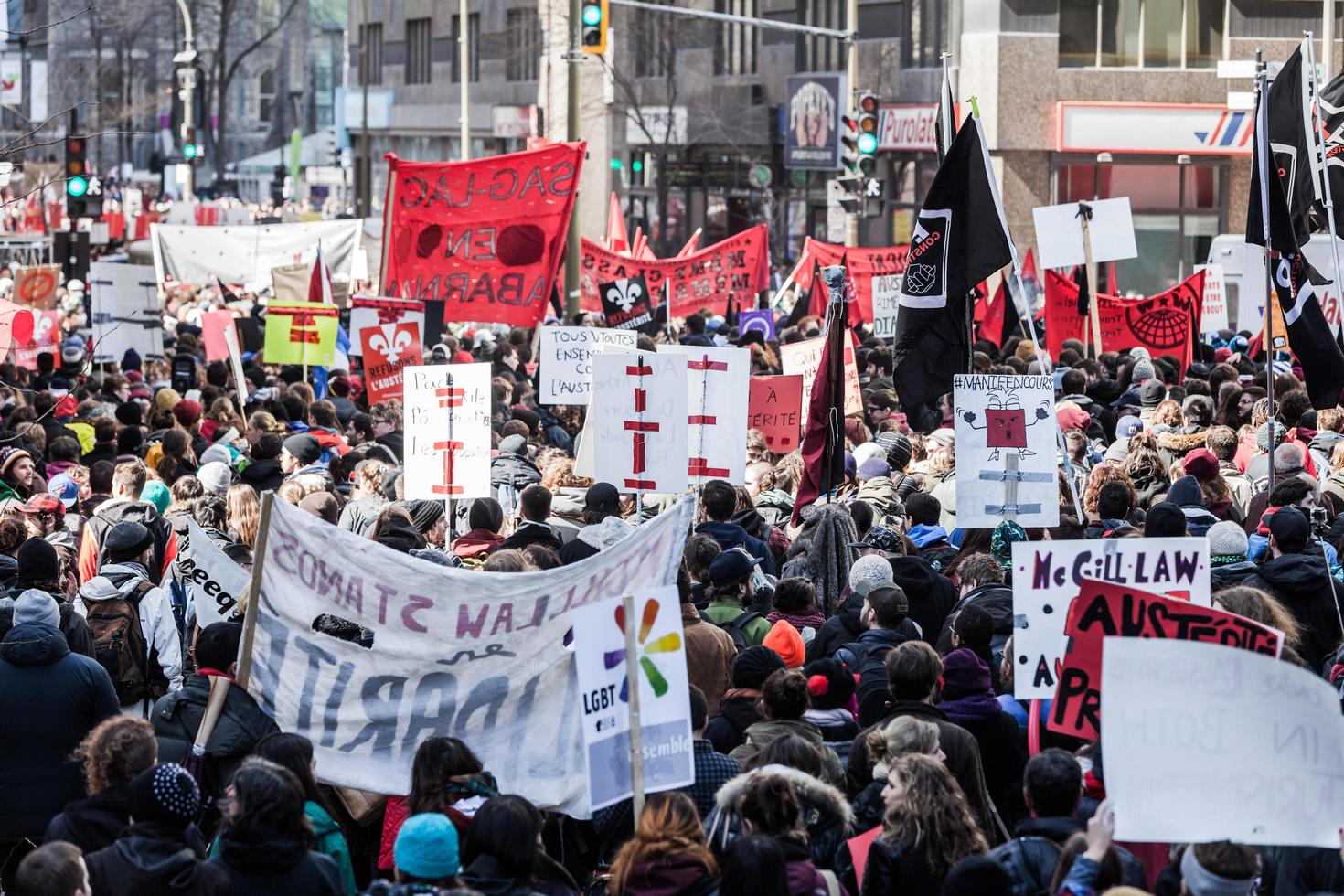 montreal, canada, 2 aprile 2015 - manifestanti con in mano tutti i tipi di cartelli, bandiere e cartelli per le strade. foto