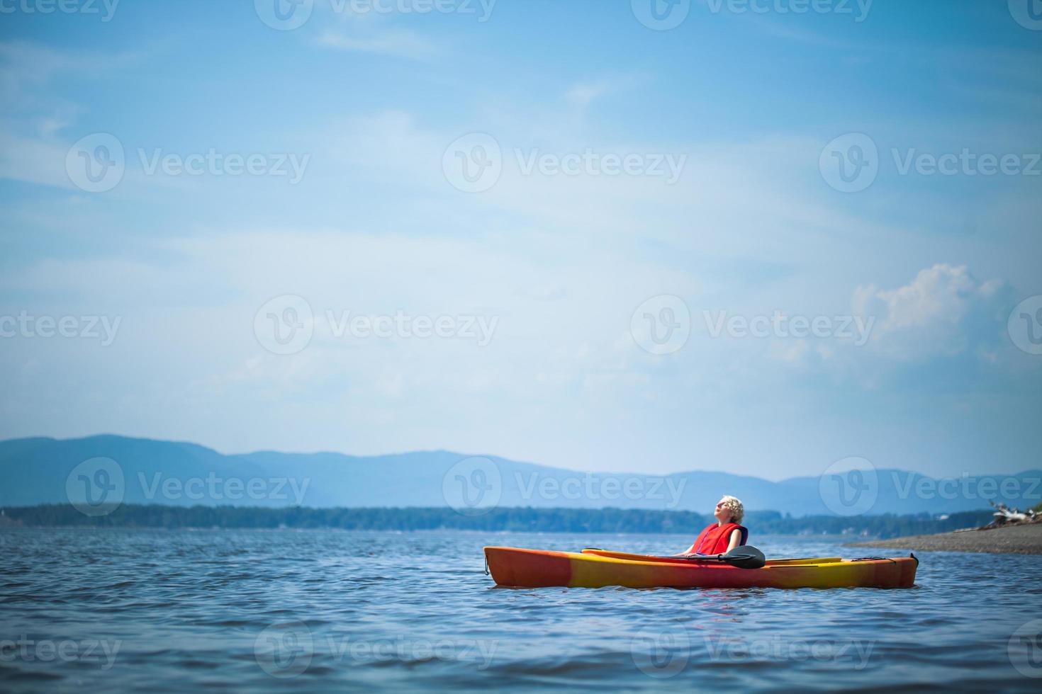 donna che si distende su un kayak e godersi la vita foto