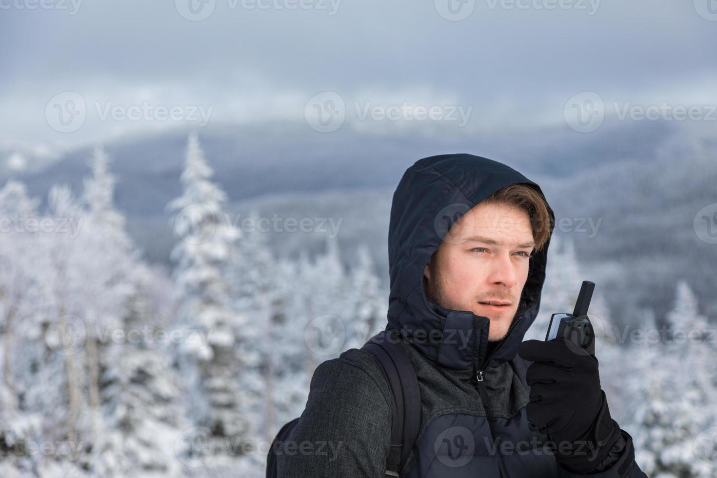 uomo in cima alla montagna in inverno foto