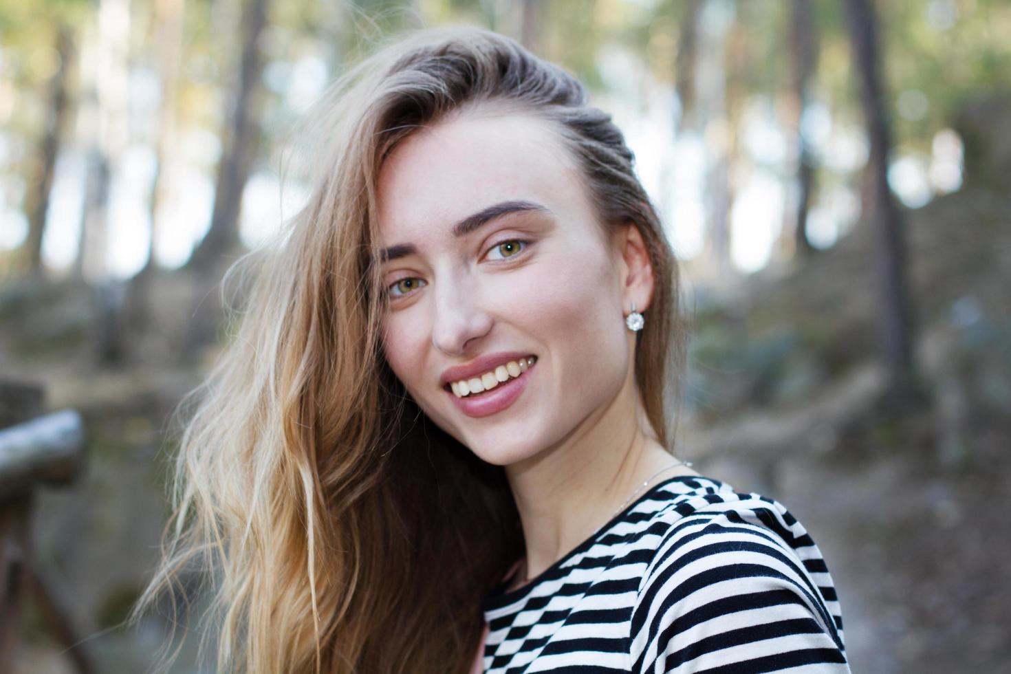 felice bella donna faccia da vicino sullo sfondo della foresta, modello di concetto di vita attiva foto