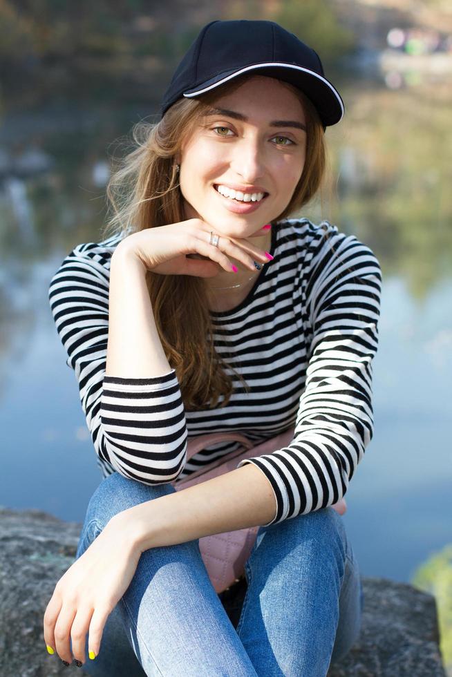 immagine verticale bella giovane donna bianca in berretto nero su uno sfondo di foresta selvaggia copia spazio, concetto di vita attiva foto