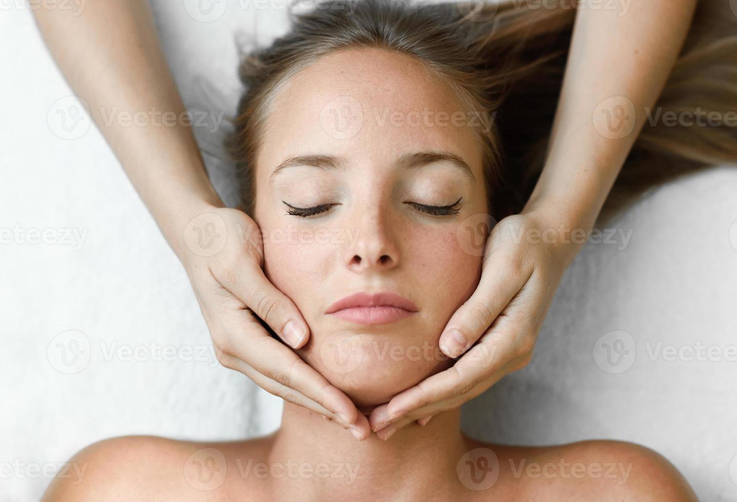 giovane donna che riceve un massaggio alla testa in un centro termale. foto