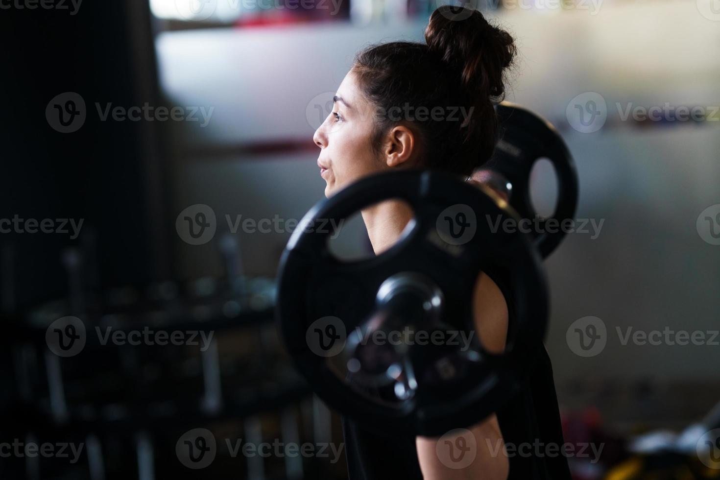 donna atletica in palestra che solleva pesi in palestra foto