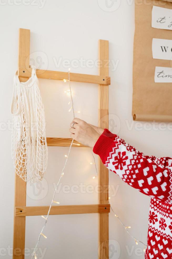 giovane donna felice in maglione di natale che fa bevande calde in cucina foto