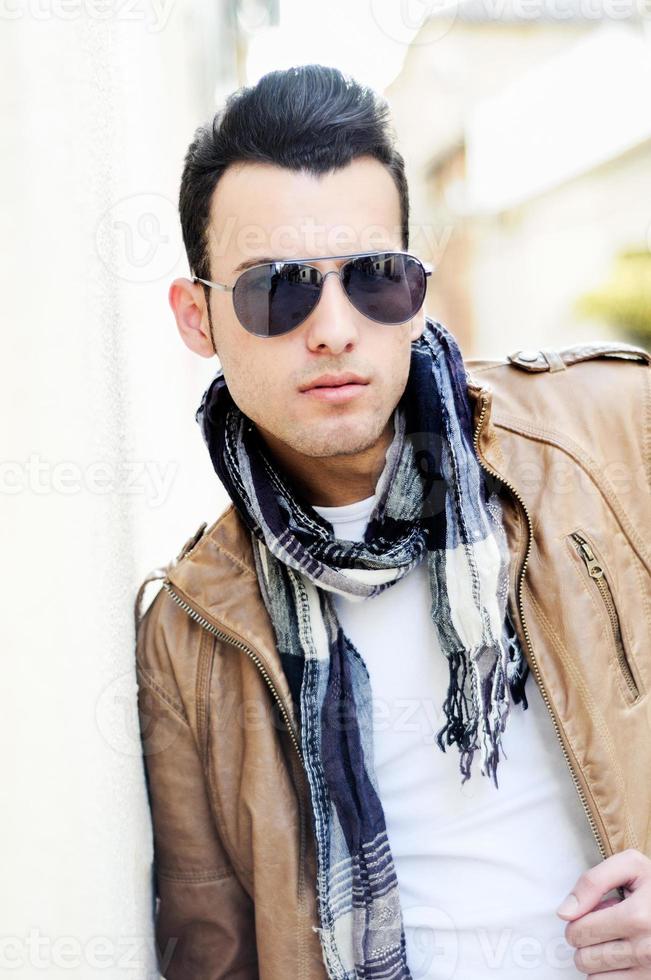 uomo attraente con occhiali da sole colorati in fondo urbano foto