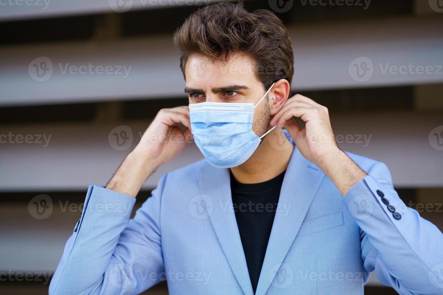 uomo d'affari che indossa una maschera chirurgica per proteggersi dal coronavirus. foto