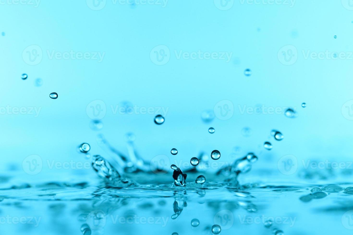 superficie dell'onda di acqua trasparente blu chiaro con bolla di spruzzi sul blu. foto