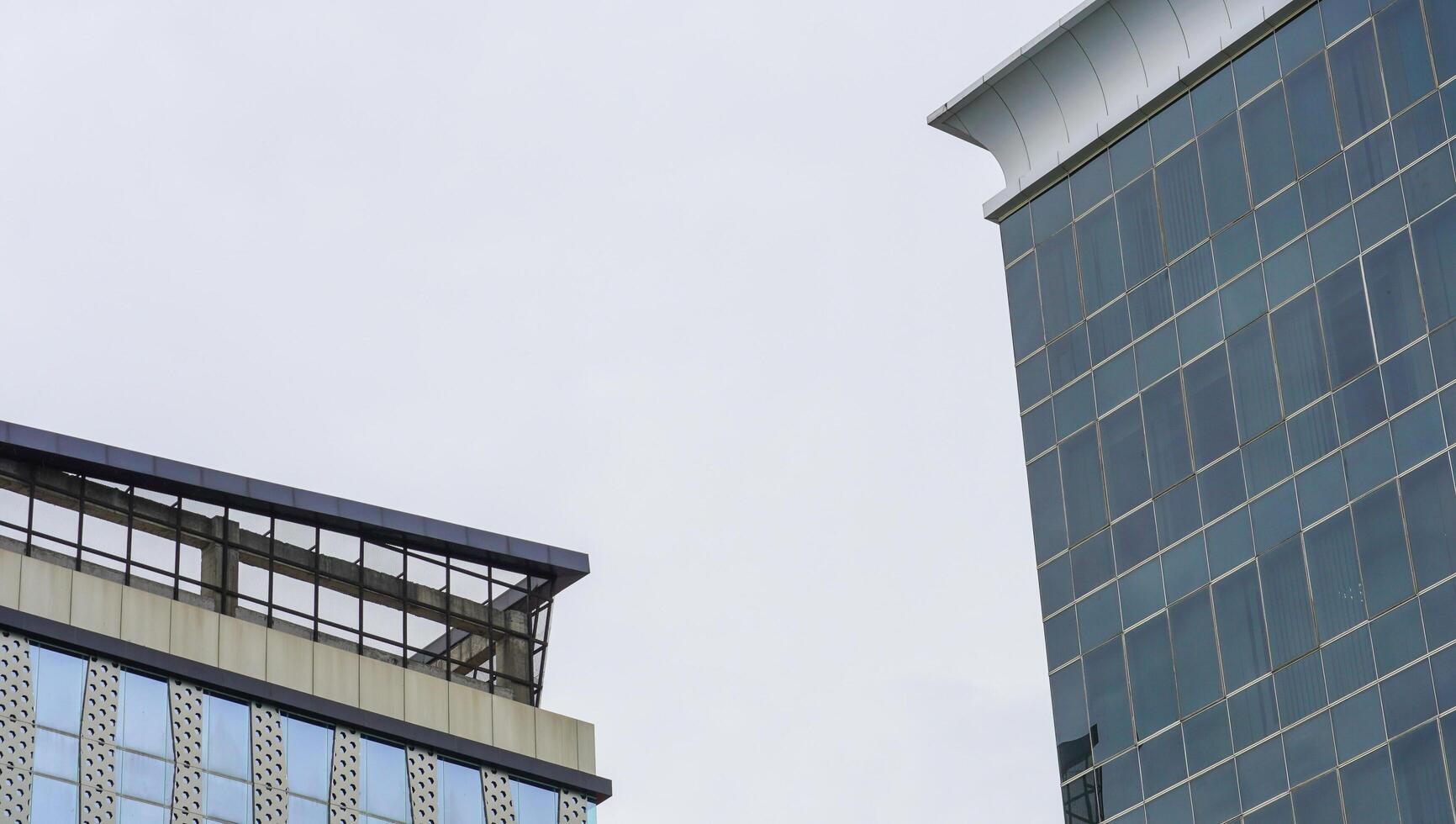 un grattacielo che ha molti materiali di vetro con uno sfondo di cielo blu. l'edificio alto nell'area urbana. foto