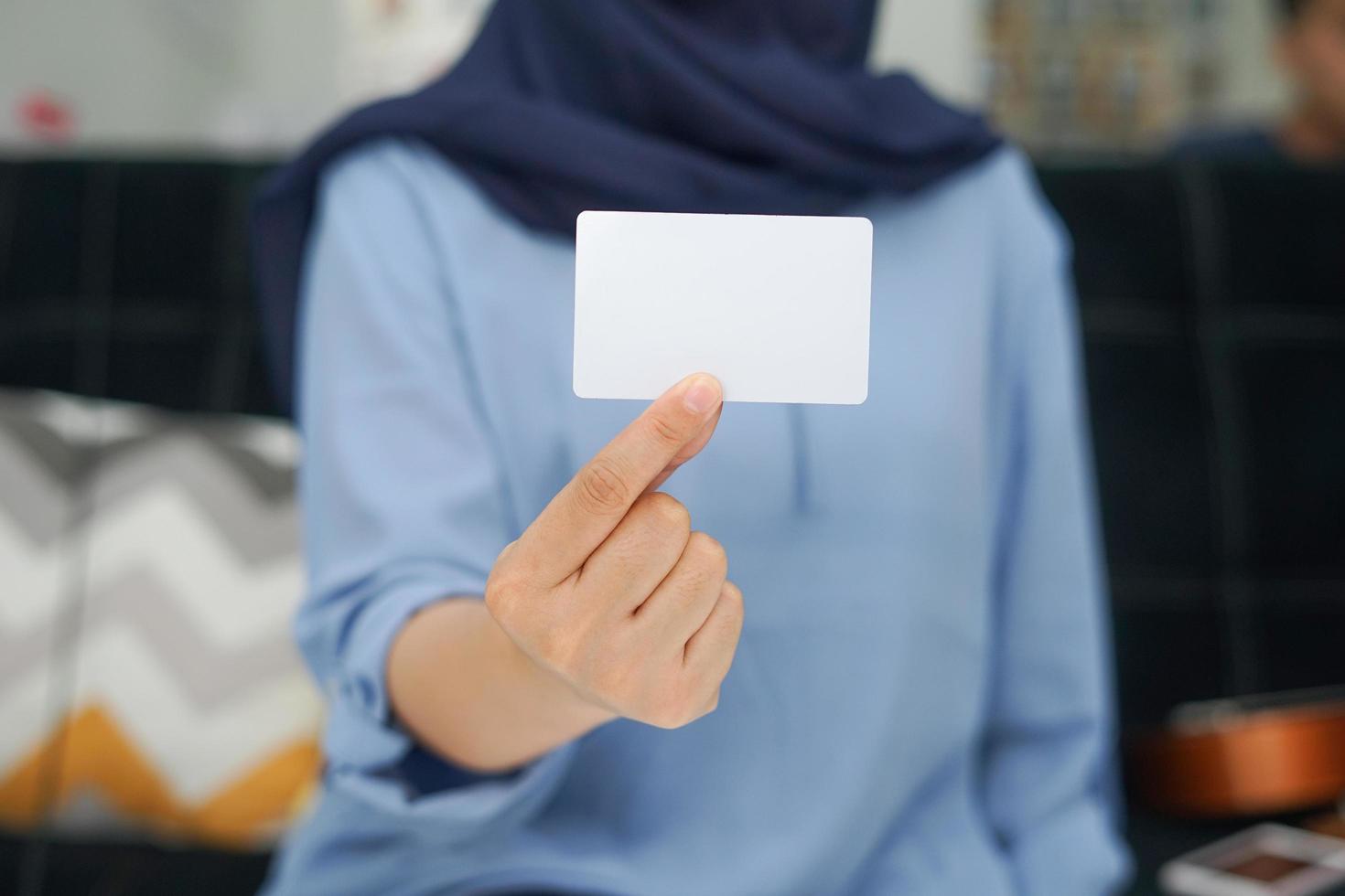 una signora con un vestito blu mostra uno spazio bianco vuoto. un mockup adatto per l'uso di mockup di identità o affari. foto