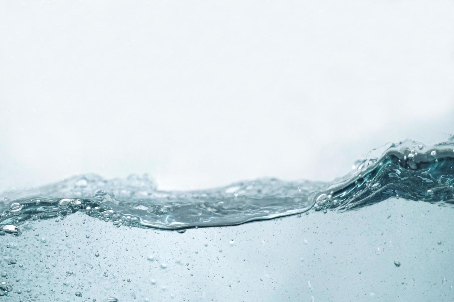 la superficie ondulata dell'acqua dalla vista laterale. la vista laterale della superficie dell'acqua isolata su bianco. struttura astratta della natura liquida. foto