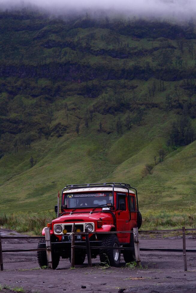 jeep rossa sotto la montagna per circondare l'area intorno alle attrazioni turistiche. i visitatori possono affittare per ottenerlo. foto