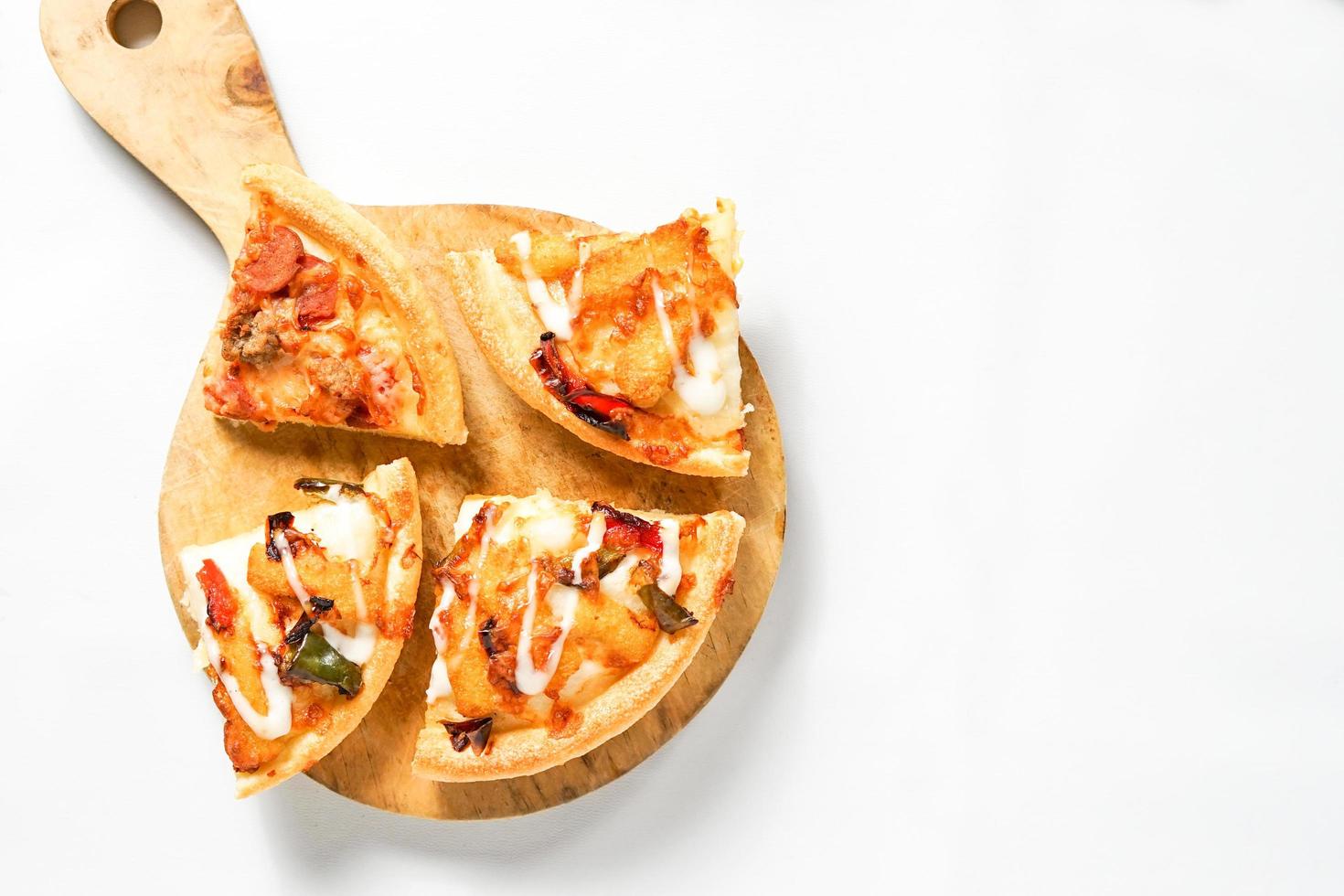 alcune fette di pizza sulla pala di legno su fondo bianco. un cibo italiano al forno con una guarnizione allettante per la pubblicità o il design di elementi. foto