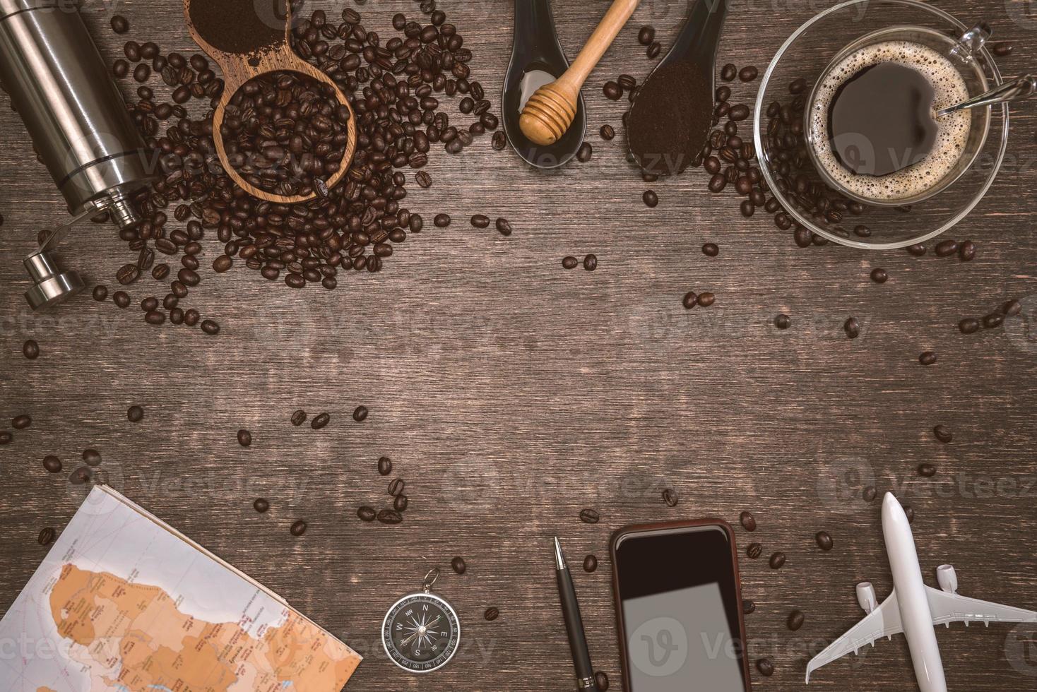 chicchi di caffè marroni e una tazza di caffè caldo posto su un tavolo di legno. concetto di viaggio con mappa. tempo per rilassarsi con una tazza di buon caffè. vista dall'alto copia spazio per il testo. foto