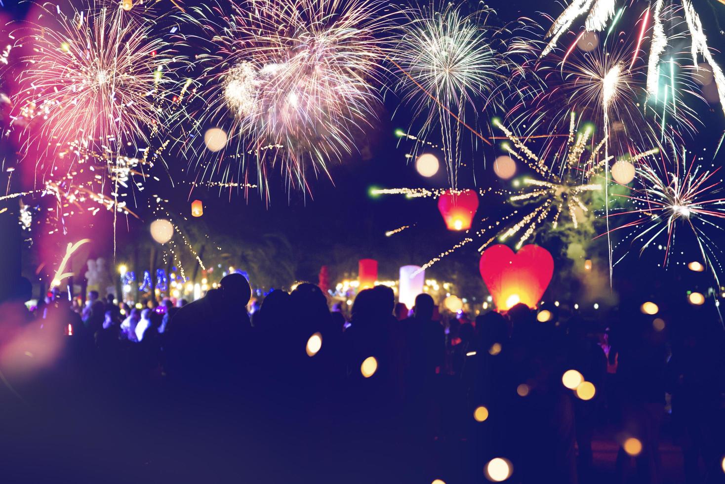 fuochi d'artificio con sagome di persone in una vacanza events.new anno fuochi d'artificio sulla spiaggia. i viaggiatori e le persone festeggiano il capodanno alla spiaggia di kamala phuket, in thailandia. foto