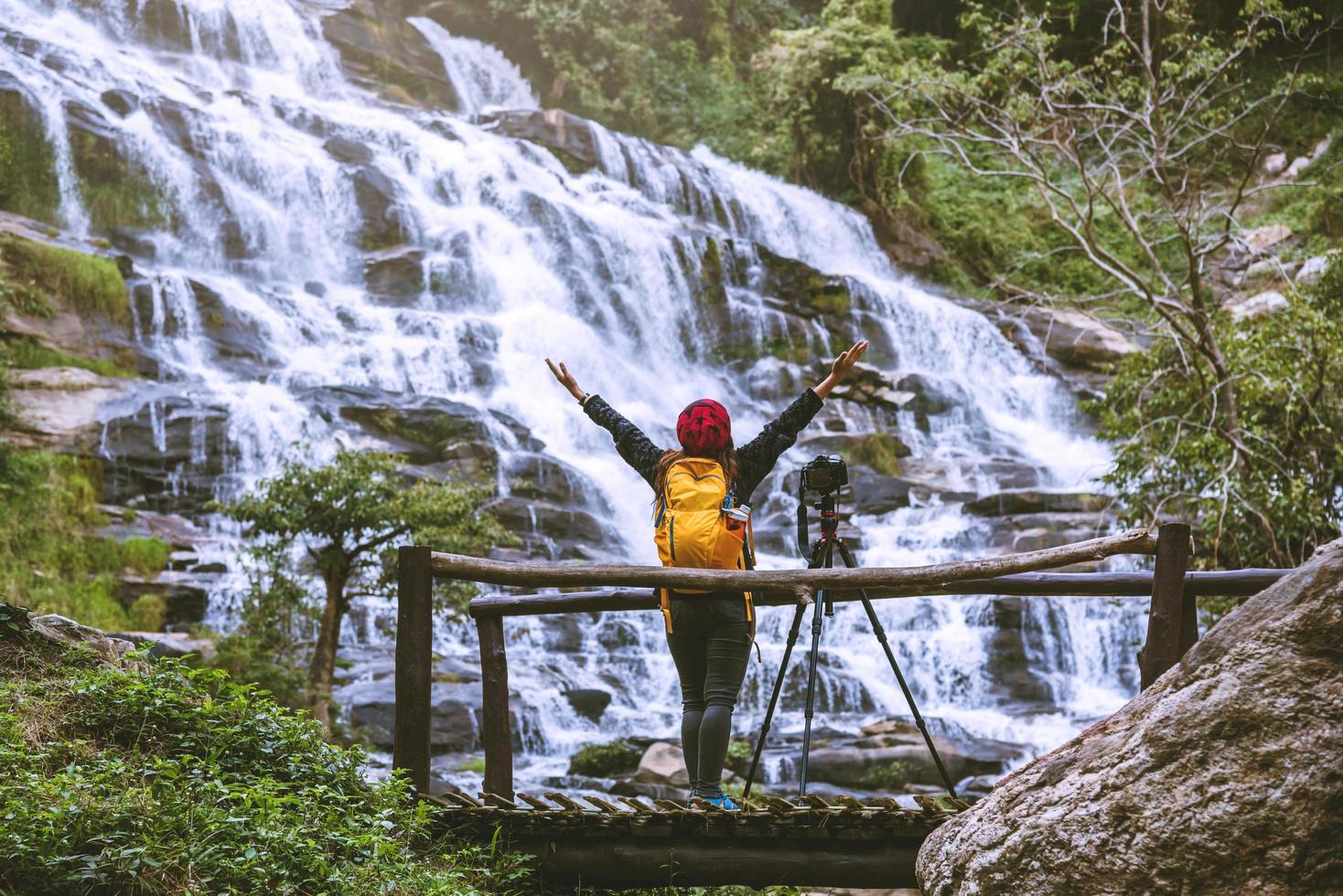 donna asiatica viaggio relax per fotografare le belle cascate. in inverno. alla cascata mae ya chiangmai in thailandia. natura di viaggio. estate foto