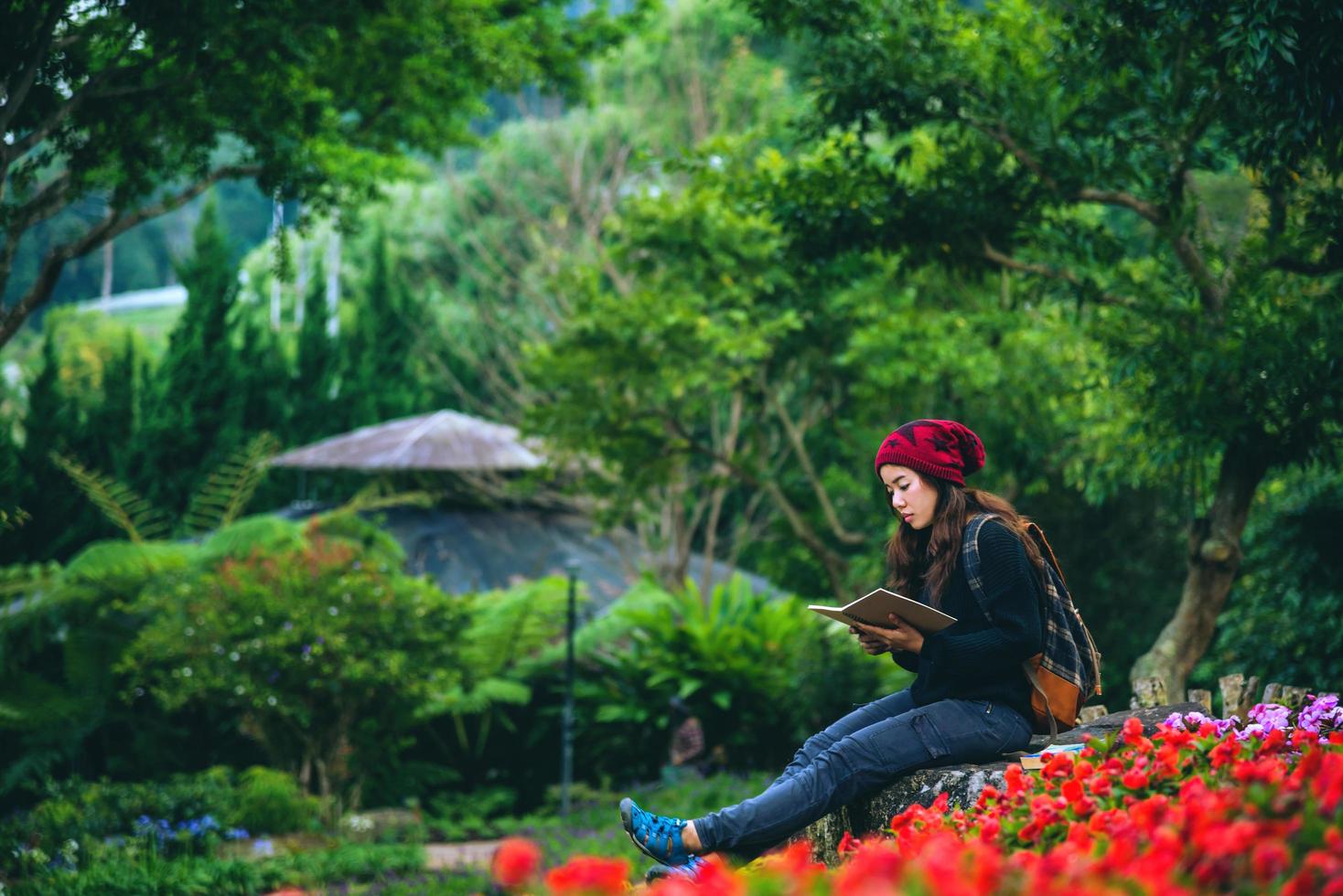 donna viaggio natura nel giardino fiorito. rilassati seduto sulle rocce e leggendo libri in mezzo alla natura nel parco nazionale doi inthanon. foto