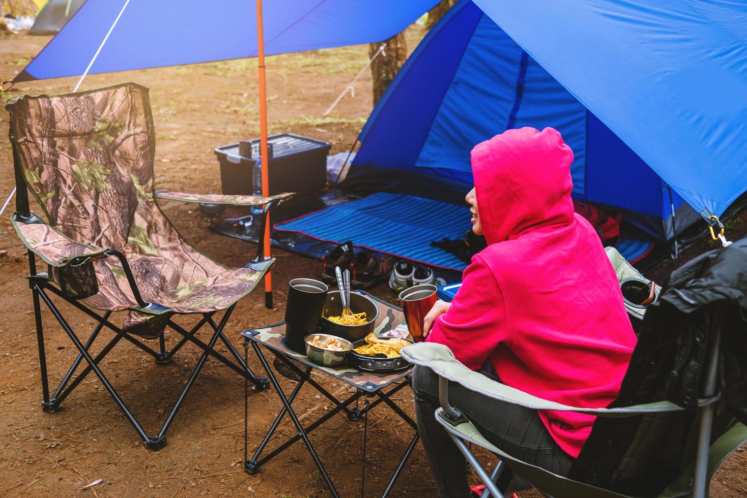 turismo natura donne, campeggio in mezzo alla pineta. sedersi e mangiare davanti alla tenda foto