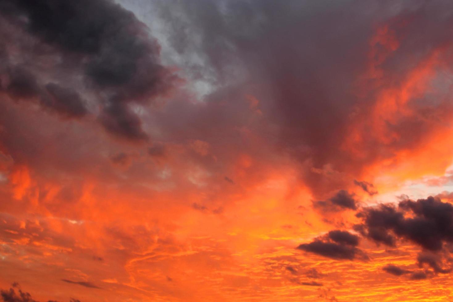 tramonto arancione brillante e alba bellissima su nuvole grigie con un sole arancione brillante in una fresca serata primaverile. foto