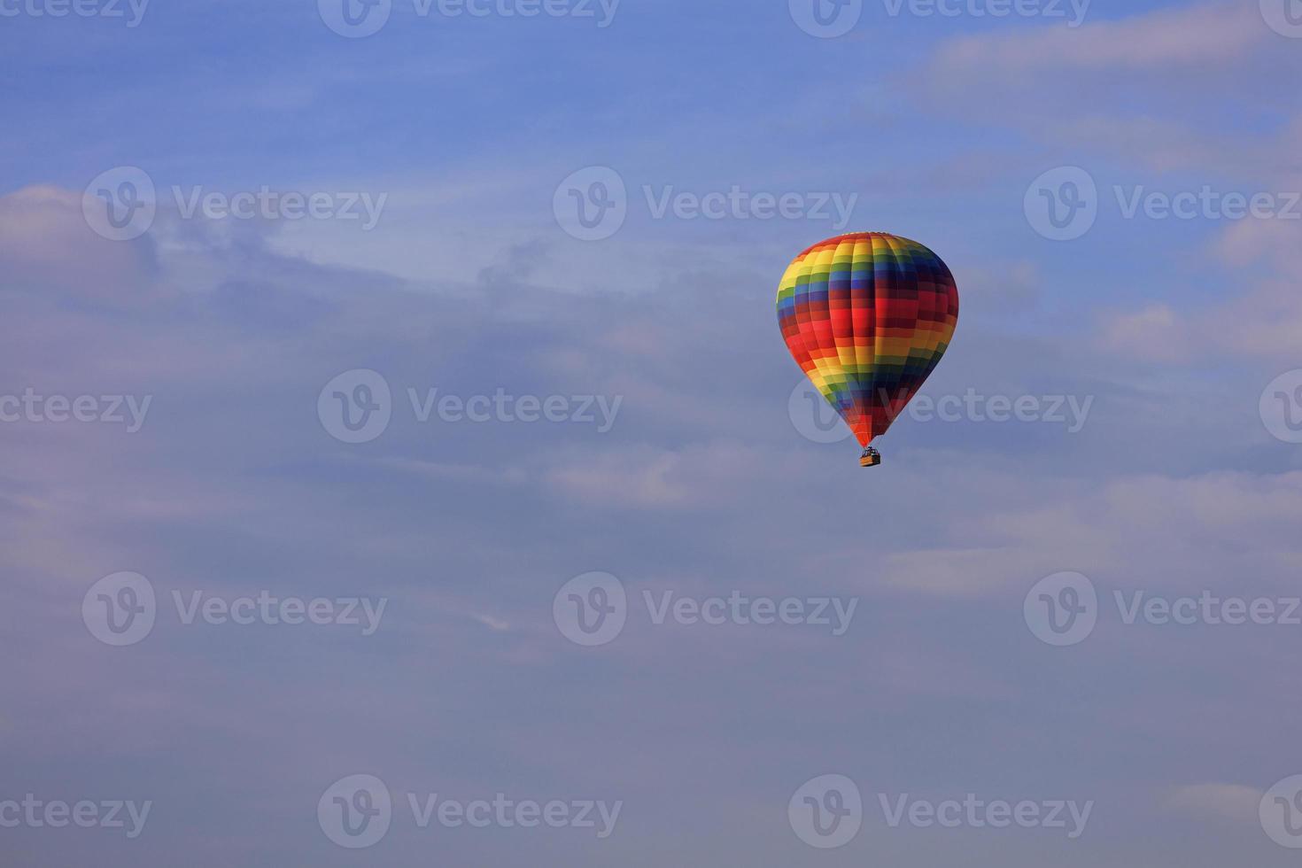 volo di un bellissimo pallone multicolore e eterogeneo nel cielo blu. foto