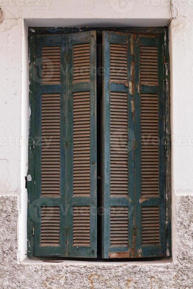persiane in legno sbucciate su una vecchia finestra. foto