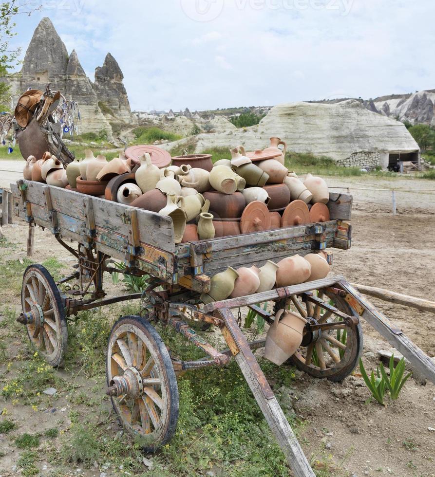 su un vecchio carro di legno, un mucchio di brocche e pentole di argilla foto