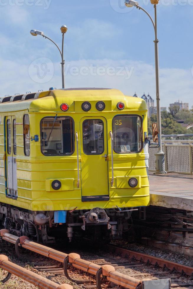 una carrozza del treno della metropolitana di colore giallo brillante sulla piattaforma di un ponte della metropolitana a kyiv. foto