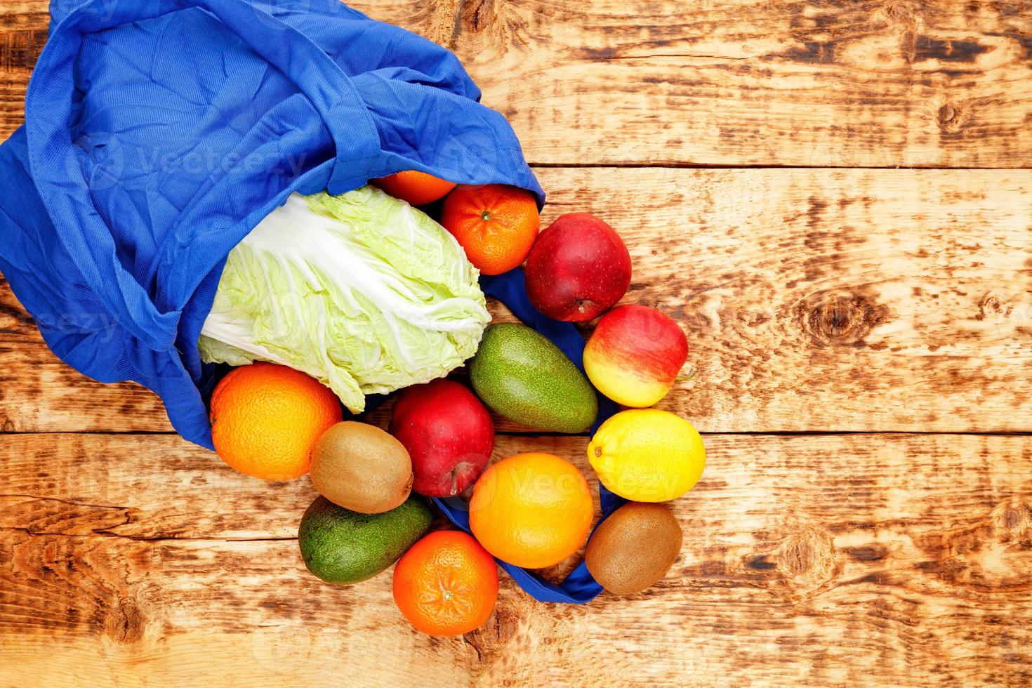 spesa alimentare zero rifiuti, borsa ecologica naturale colore blu classico con frutta e verdura su un vecchio tavolo di legno. foto