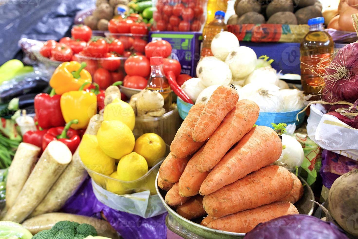 carote, pomodori, cipolle, peperoni e altri ortaggi, ortaggi a radice e limoni, olio di semi di girasole vengono venduti sugli scaffali del mercato. foto