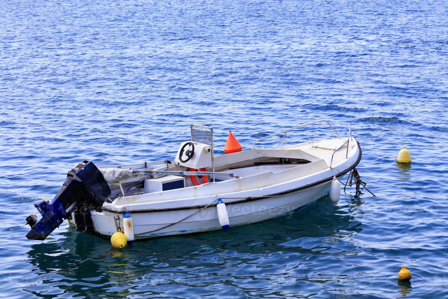 una barca a motore è ancorata nelle limpide acque del mar Ionio. foto