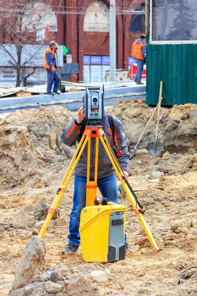 un tecnico dell'assistenza stradale utilizza una livella laser in un cantiere edile. foto