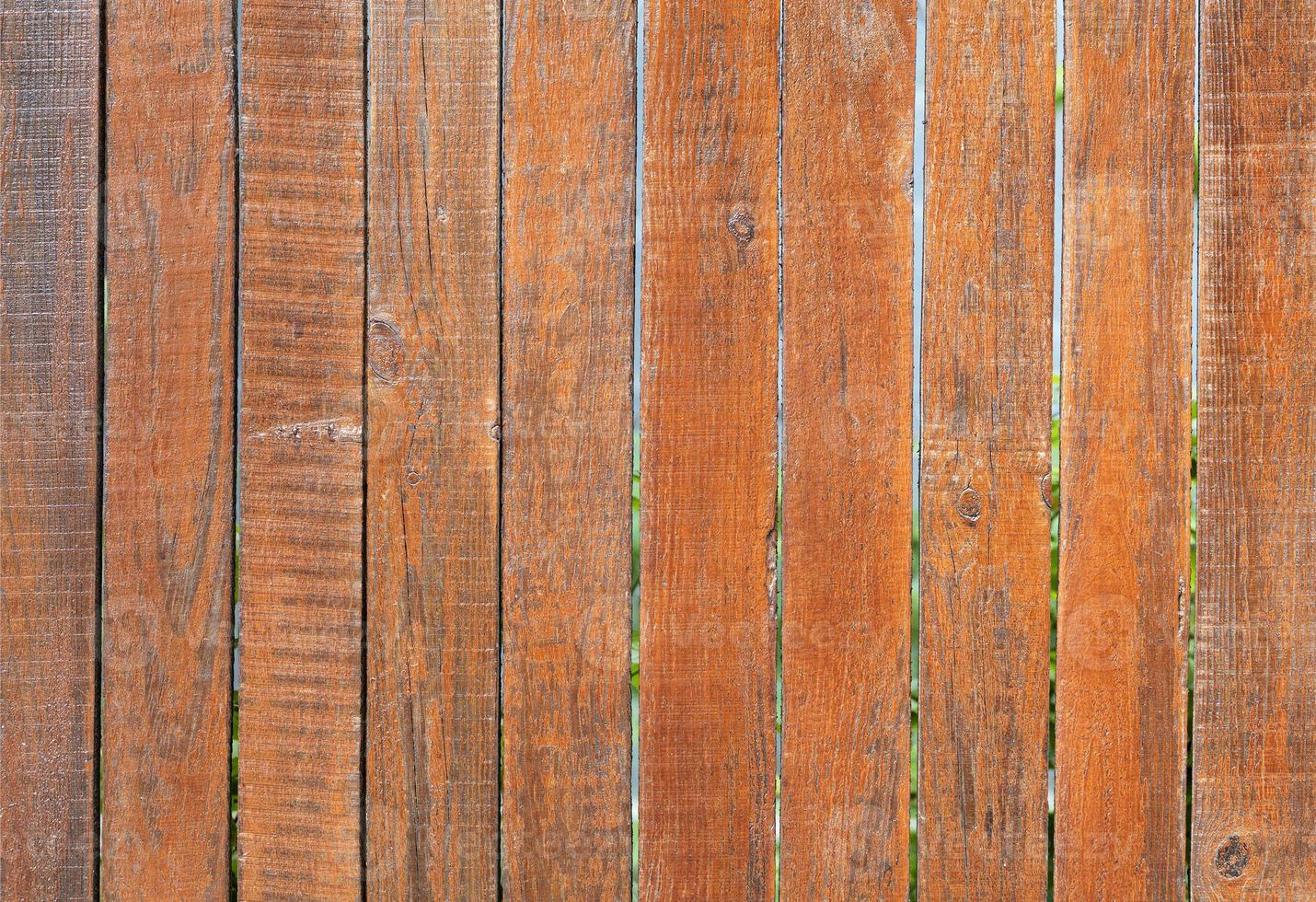 il vecchio recinto di legno grigio stagionato è dipinto con un colore arancione brillante, primo piano foto