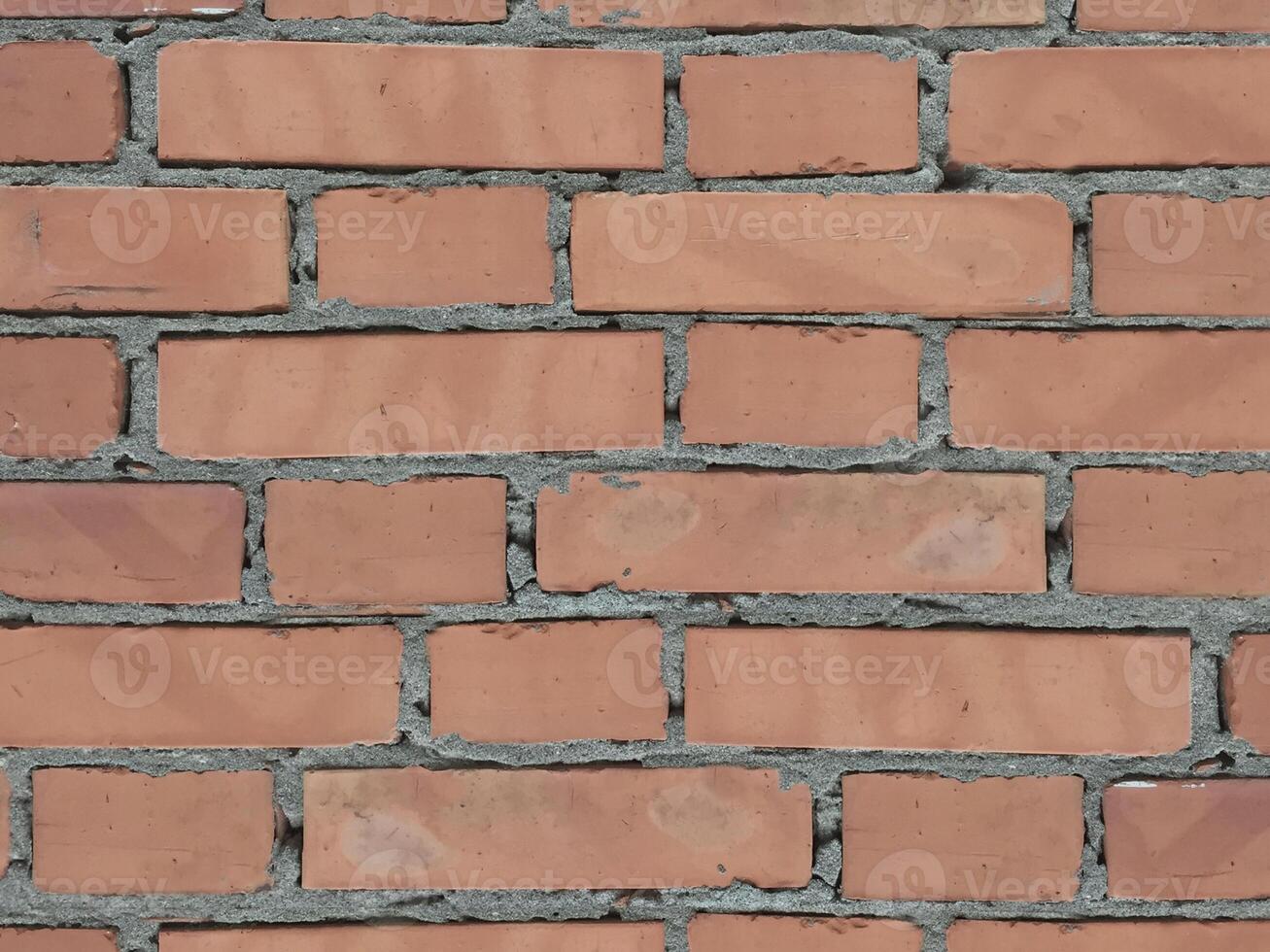 muro di pietra perfettamente organizzato, trama rosso mattone chiaro dalla trama di sfondo del muro di roccia foto