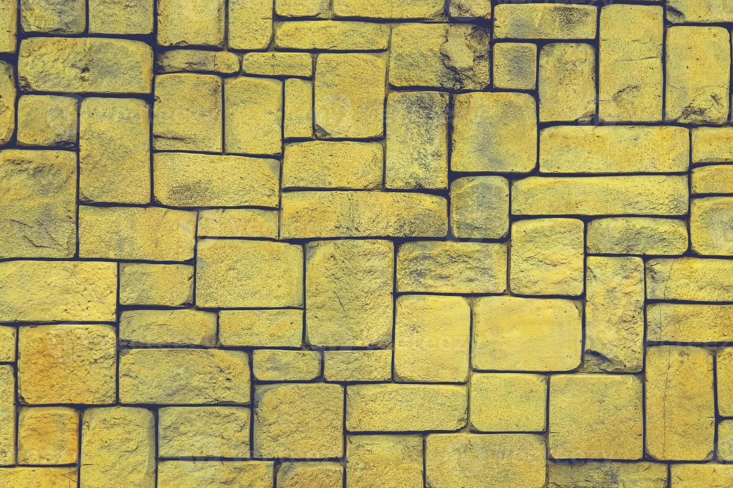 muro di pietra perfettamente organizzato, trama gialla e nera dalla trama di sfondo del muro di roccia foto