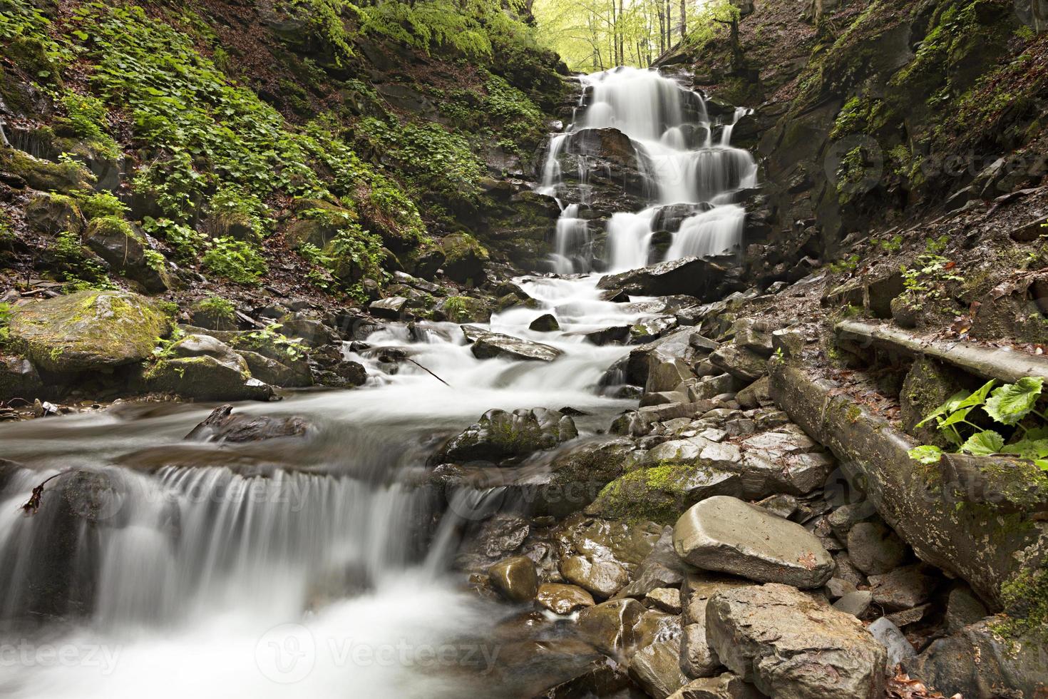 cascata di massi sulla cascata di un fiume di montagna veloce tra le colline dei Carpazi. foto