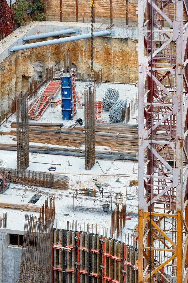 frammento di una gru a torre sullo sfondo di un cantiere con casseforme e raccordi. foto