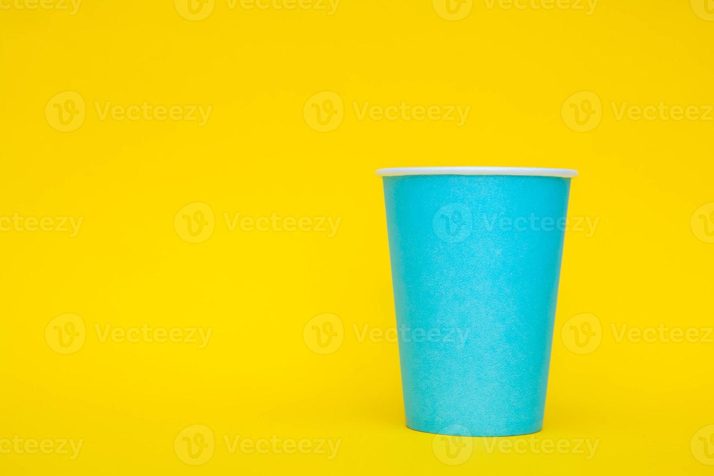 bicchiere di carta blu su sfondo giallo foto