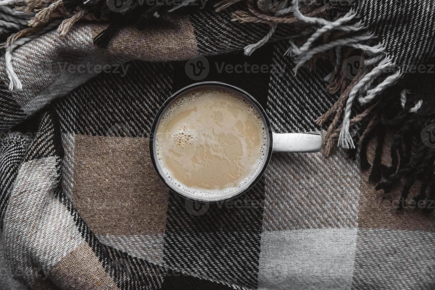 tazza di bevanda calda su sfondo accogliente plaid. vista dall'alto, copia spazio foto