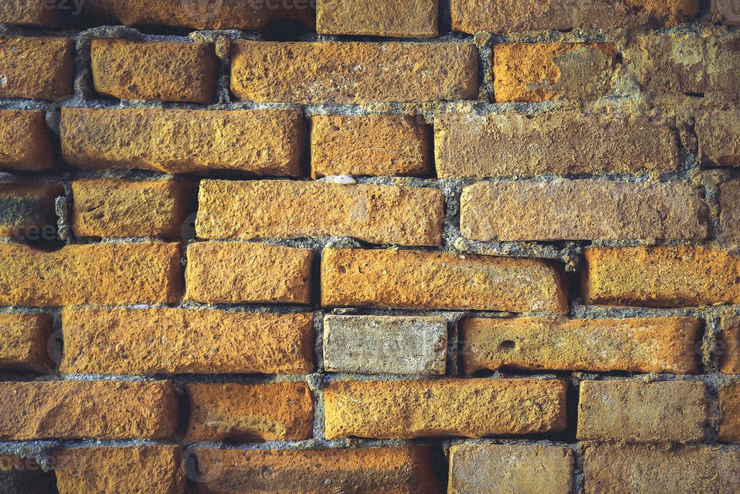 muro di pietra perfettamente organizzato, trama arancione dalla trama di sfondo del muro di roccia foto