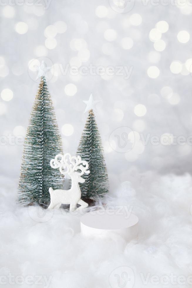 podio o piedistallo mok-up per cosmetici nella neve con un albero di natale su sfondo bokeh formato verticale foto