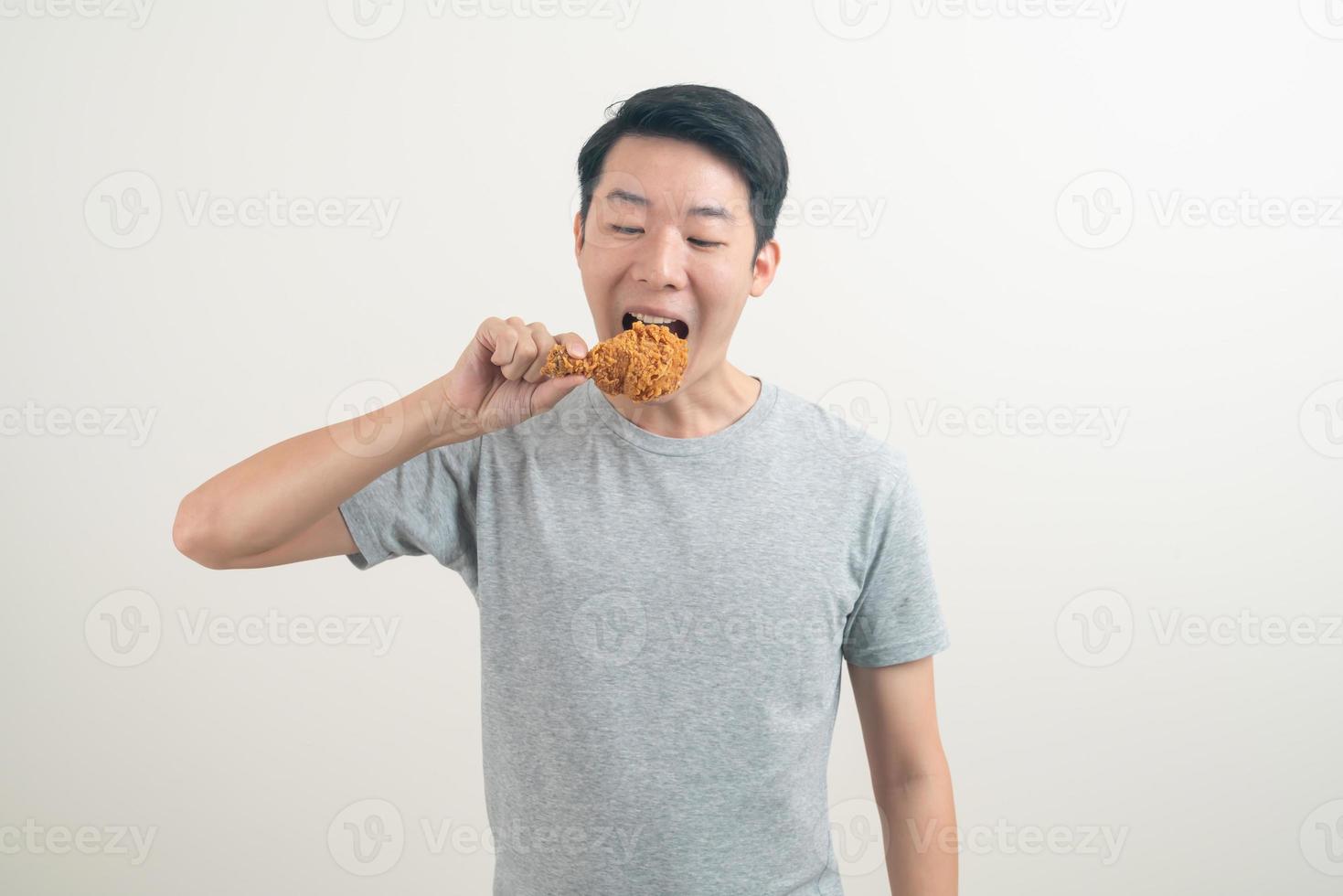 giovane uomo asiatico con pollo fritto a portata di mano foto