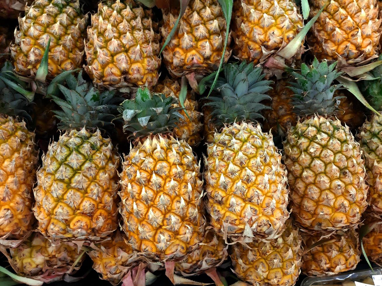 ananas disposti in vassoi per la vendita al mercato, ananas inviati dall'orto ai consumatori, immagini di sfondo. foto