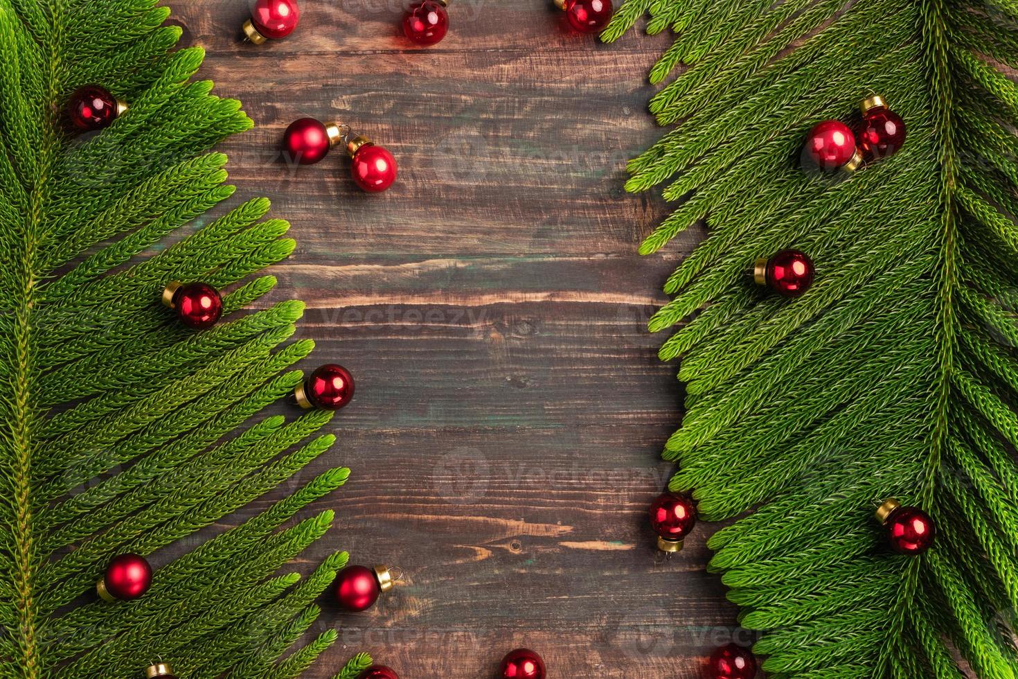 foglia di pino di natale con decorazione a pallina rossa su tavola di legno foto