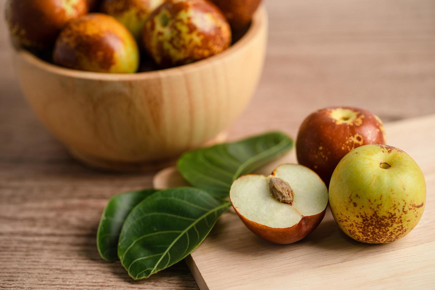 frutta di giuggiola o datteri cinesi in ciotola di legno, cibo sano. foto